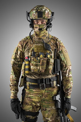Soldier holding assault rifle. Uniform conforms to special services of the Russian Federation. Shot in studio. Isolated with clipping path on grey background