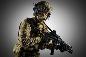 Fototapeta premium Soldier holding assault rifle. Uniform conforms to special services of the Russian Federation. Shot in studio. Isolated with clipping path on grey background
