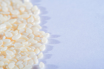 Light background with scattered sesame seeds at high magnification and an empty white background with space for inscriptions