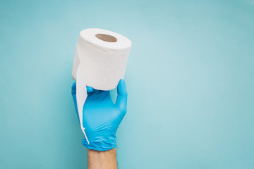 Hand holding roll of toilet paper over blue background