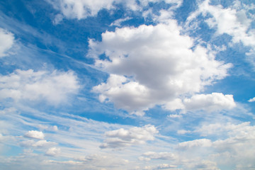 Horizontal view of a light, blue sky with white clouds. Airy, vibrant atmosphere