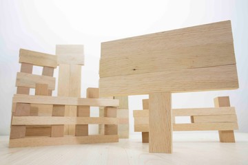 Building from wooden cubes and rods. The photo was taken on the white background and on the table. Close up.