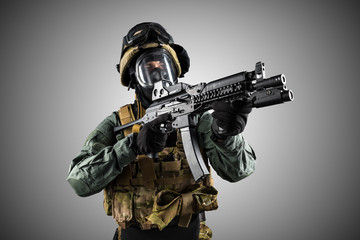 Soldier holding assault rifle. Uniform conforms to special services of the Russian Federation. Shot in studio. Isolated with clipping path on grey background