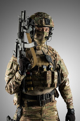 Fototapeta premium Soldier holding assault rifle. Uniform conforms to special services of the Russian Federation. Shot in studio. Isolated with clipping path on grey background