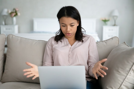 African Woman Sit On Sofa Put Notebook On Lap Has Problems With Device Looks At Screen Feels Annoyed By Unexpected Pc Shut Down Unsaved Documents Turn Off Without Warning, Need Repair Service Concept