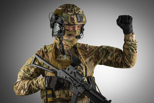 Soldier holding assault rifle. Uniform conforms to special services of the Russian Federation. Shot in studio. Isolated with clipping path on grey background