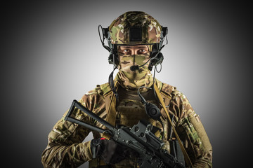 Fototapeta premium Soldier holding assault rifle. Uniform conforms to special services of the Russian Federation. Shot in studio. Isolated with clipping path on grey background