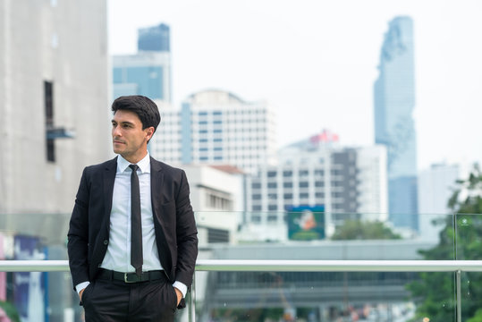 Portrait of businessman in black suit in city finding job during crisis