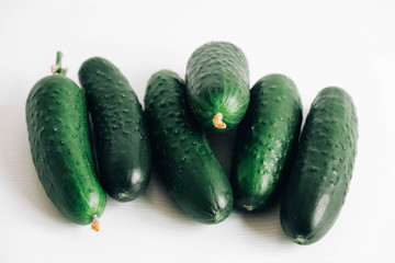Fresh green cucumbers on white background. Top view. Copy, empty space for text