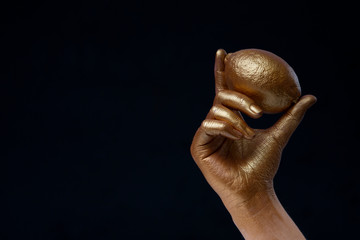 Creative concept with fruit. Golden lemon in hand