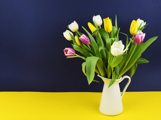 Colorful tulip flowers in a white jag on blue and yellow background