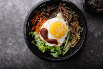 Korean dish bibimbap. Top view close up. Nearby are the Korean sticks.