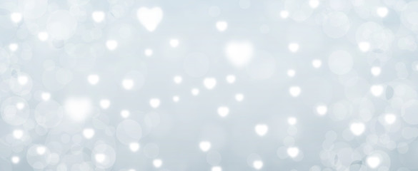 Glowing soft grey bokeh background. Spring concept. Blurred bokeh circles and hearth shapes.  Website banner. Celebration.  Christmas.