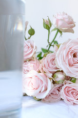 Roses lie on a table next to a vase