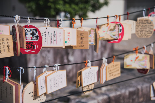 Tablillas de madera ema con forma de Daruma a la entrada de un templo japon&eacute;s