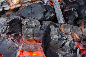 hot coals burn down with orange fire, leaving ashes. Summer tourism in nature and camping