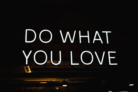 "Do what you love" neon sign with dark background.