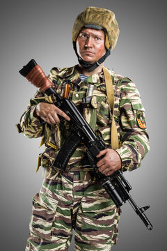 Male in uniform conforms to Russian army special forces (OMON) in War in Chechnya. Isolated on grey background