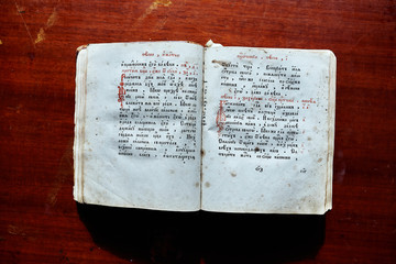 Old book with ancient text on a wooden table