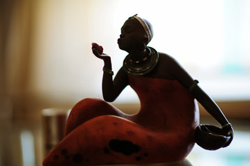 STATUETTE. Dark-skinned girl sitting. Beautiful girl