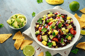 Avocado, mango salad with black bean, tomato, red onion and tortilla chips. healthy food