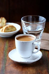 Naklejka premium Cup of coffee with cantuccini (Italian cookies) on rustic wooden background.