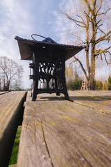 Black metal lantern with a roof, a flat candle inside, which stands on a wooden table