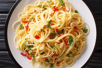 Italian food spaghetti Aglio e Olio with fried garlic, parsley and hot pepper close-up in a plate. Horizontal top view