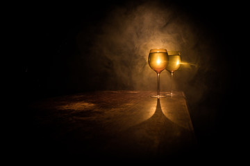 Fototapeta na wymiar Goblet of white wine on wooden table on wooden wall background