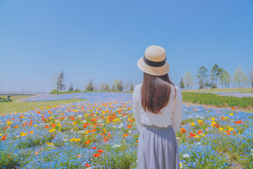 Fototapeta na wymiar Girls and blue flowers on the hillside，sunny and happy life