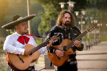 Obraz premium Mexican musicians play musical instruments in the city. City street in the summer.