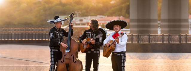 Mexican musicians play musical instruments in the city. City street in the summer.