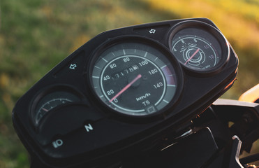 black control panel and standard motorcycle speedometer photographed close up