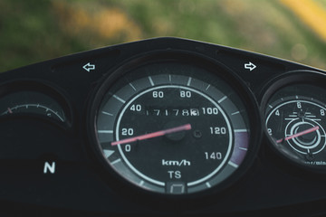 black control panel and standard motorcycle speedometer photographed close up