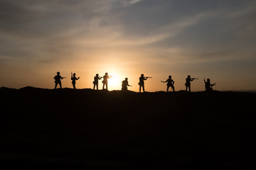 War Concept. Military silhouettes fighting scene on war fog sky background, World War Soldiers Silhouette Below Cloudy Skyline At sunset.