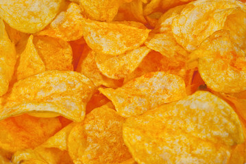 Texture of yellow crispy chips. Lots of chips close up.