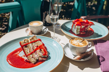 Early breakfast on the veranda on a sunny summer day. Summer dessert with strawberries and a cup of kofi. Breakfast for two.