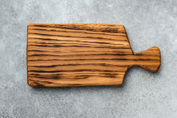 Wooden cutting board isolated on concrete background, top view