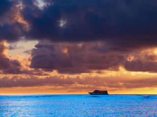Fototapeta na wymiar Panoramic View of a beautiful Sunset on Waikiki Beach Honolulu Hawaii with blue waters and grey cloudy skies