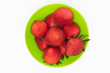 Juicy red strawberries as a symbol of summer in a green bowl