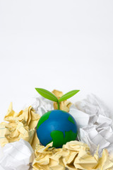 green sprout on globe with garbage heap