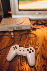 Old game joysticks and a console on a wooden table. An ancient computer game. Game-playing in the late 90s
