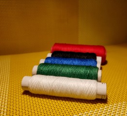 Multicolor sewing threads with dark background.