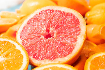 Fototapeta na wymiar Macro and close up focus on one cut piece grapefruit in the center of oranges slices