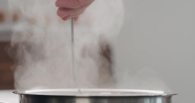 Slow motion stiring boiling water in saucepan while cooking