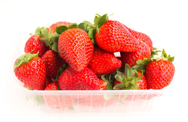 fresh appetizing strawberries in a plastic tray onwhite background