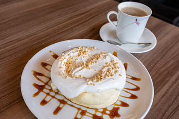 カラメルソースとナッツと生クリームの乗ったパンケーキとコーヒー
