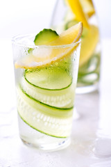 Cold and refreshing infused detox water with lemon and cucumber in a glas. Homemade flavored lemonade