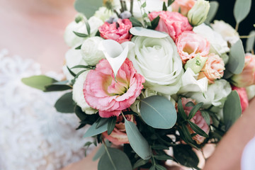 bride in a white dress with a chic bouquet in her hands. Luxury wedding bouquet. The girl is holding flowers - roses, peonies, archedes.