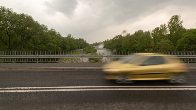 Rozmyte auto na moście w czasie deszczu 
